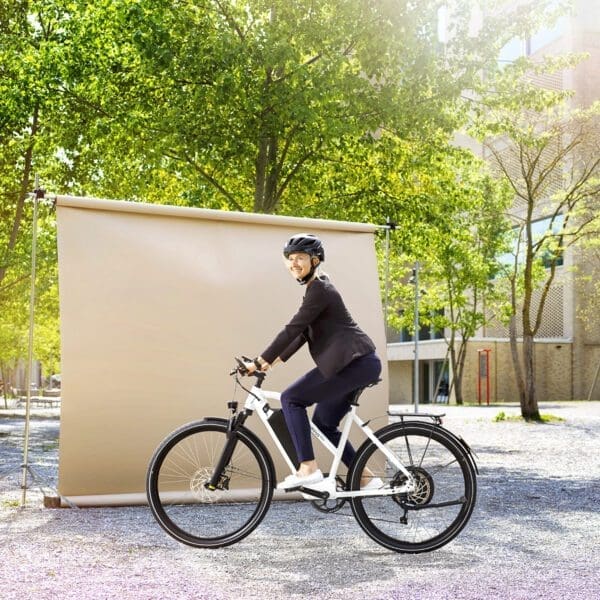 Power, Frau an Universität Eine Frau mit ihrem Power45 E-Bike von AureusDrive, die zur Universität fährt.