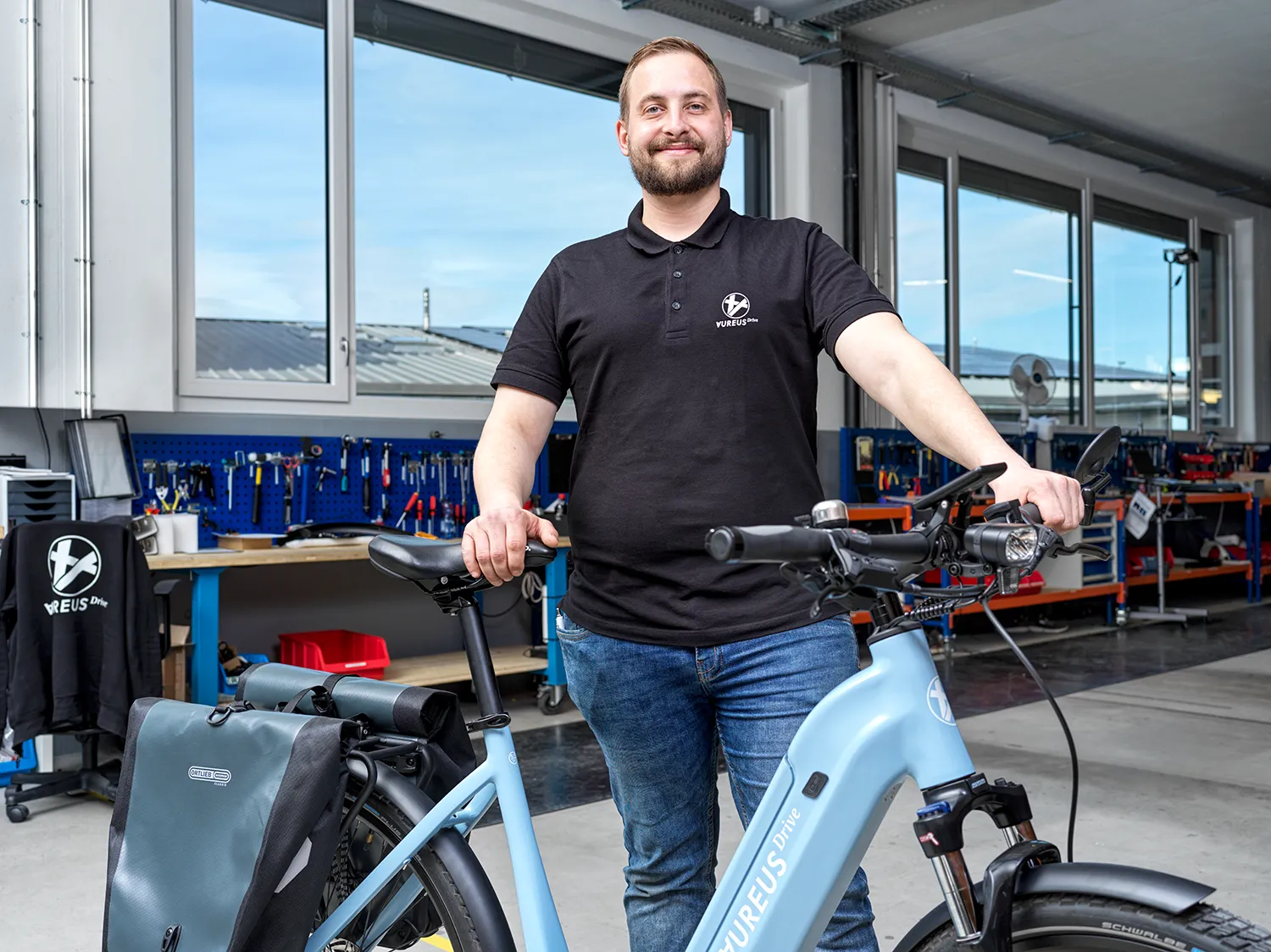 Mechaniker, der stolz das gebaute AureusDrive E-Bike des Modells DailyDrive präsentiert.