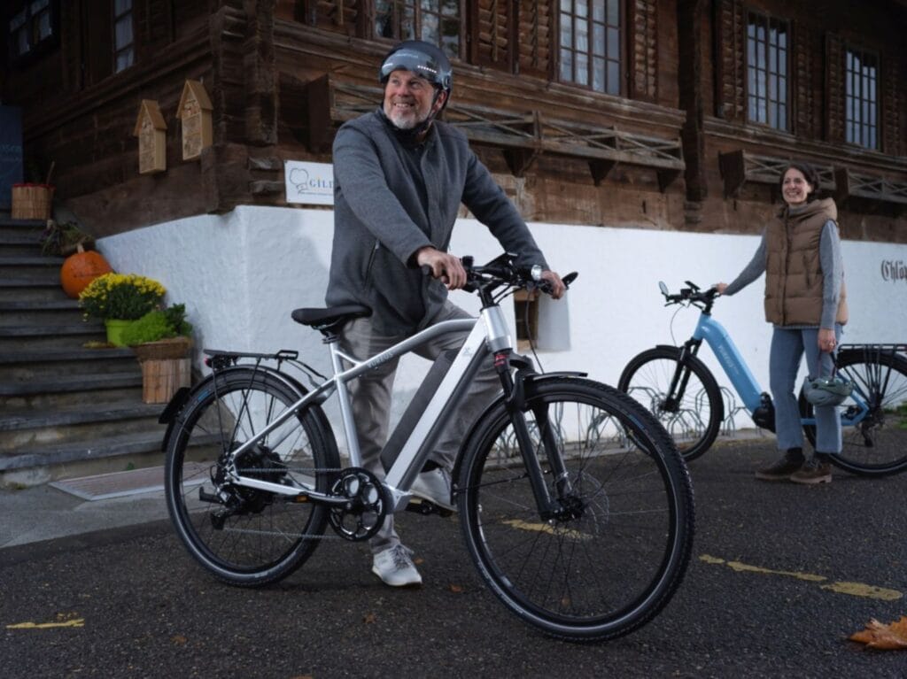 Mann und Frau vor einem Landhaus mit den AureusDrive E-Bike Power45 und DailyDrive Modellen.