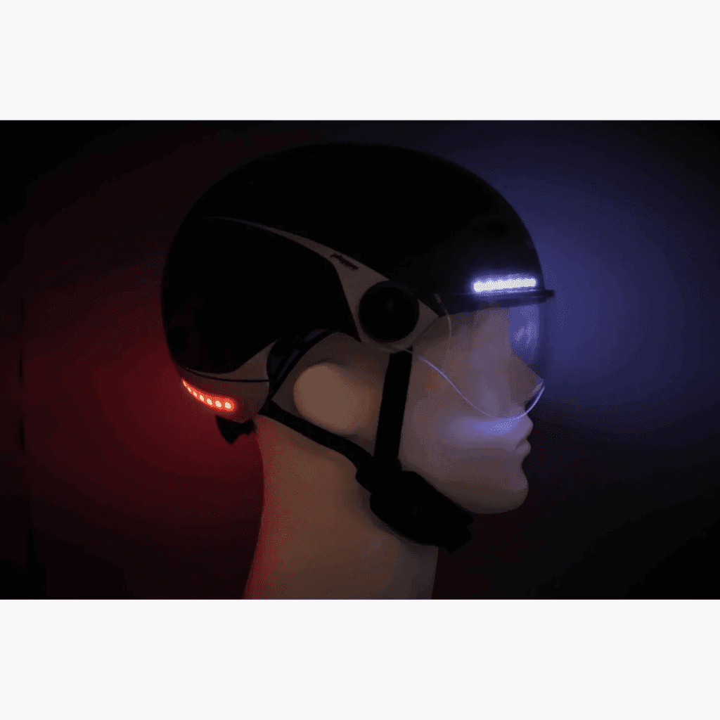 Black Phenix e-bike helmet in the dark. With a white front light and red taillights.